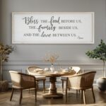 White wooden wall sign with "Bless The Food Before Us" text, in a rustic farmhouse style, 40x11 inches.