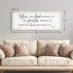 White wooden wall sign with "Bless The Food Before Us" text, in a rustic farmhouse style, 40x11 inches.