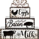 A set of four black and white wooden farmhouse signs, featuring a cow, rooster, and pig, displayed on a tiered tray.