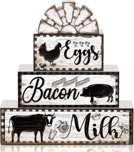 A set of four black and white wooden farmhouse signs, featuring a cow, rooster, and pig, displayed on a tiered tray.