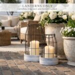 Two KIBAGA rustic farmhouse lanterns, one large and one small, with distressed black and white finishes, on a tabletop.