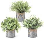 Three small artificial plants: eucalyptus, boxwood, and rosemary, each in a grey galvanized metal pot with a jute rope bow, a