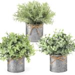 Three small artificial plants: eucalyptus, boxwood, and rosemary, each in a grey galvanized metal pot with a jute rope bow, a