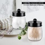 Two black acrylic mason jar qtip holders with lids and labels, displayed on a bathroom counter.