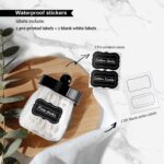 Two black acrylic mason jar qtip holders with lids and labels, displayed on a bathroom counter.
